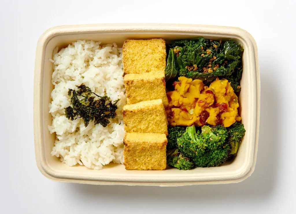 Korean tofu plate with kimchi, greens, and sides at Sopo Korean Eats Midtown NYC.