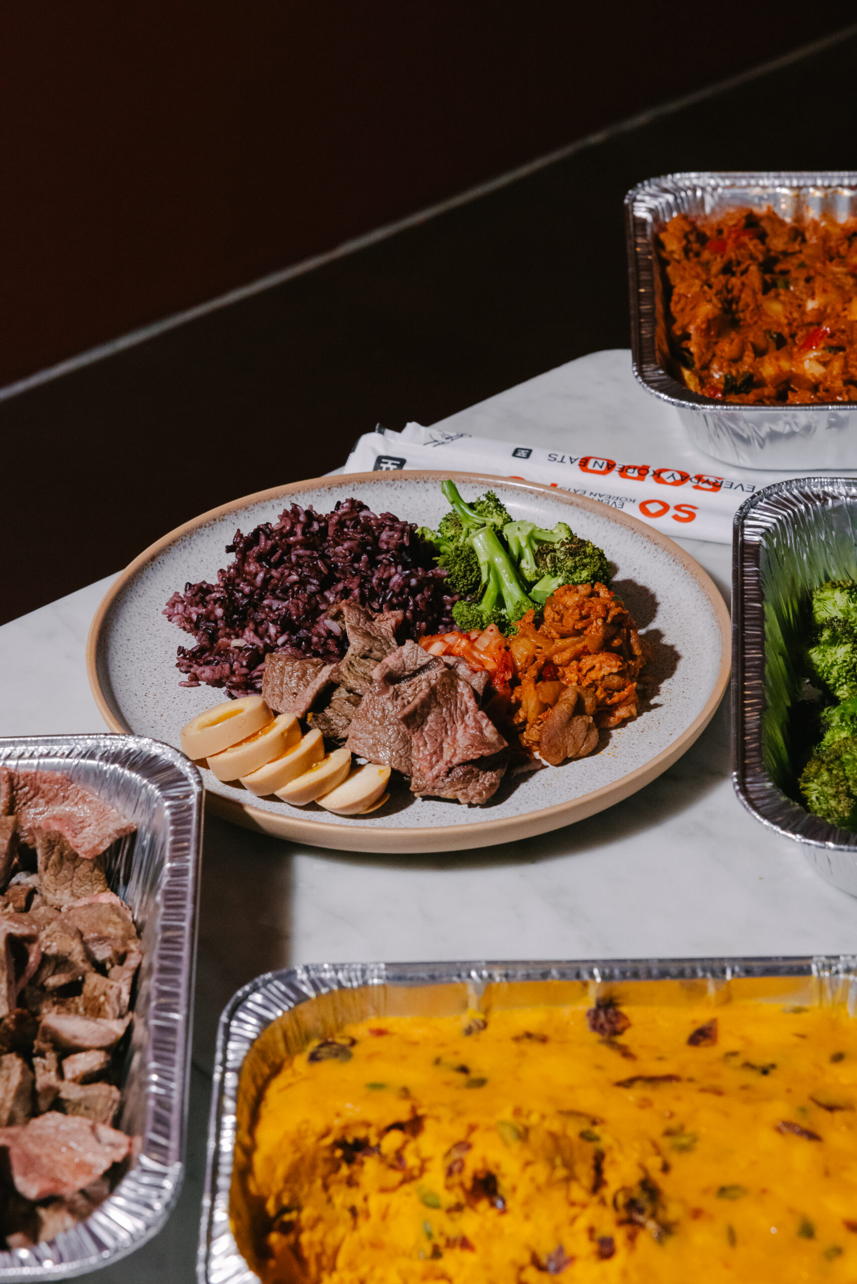 Korean office lunch spread from Sopo Korean Eats in Midtown NYC with a bulgogi plate, kimbap, and sides